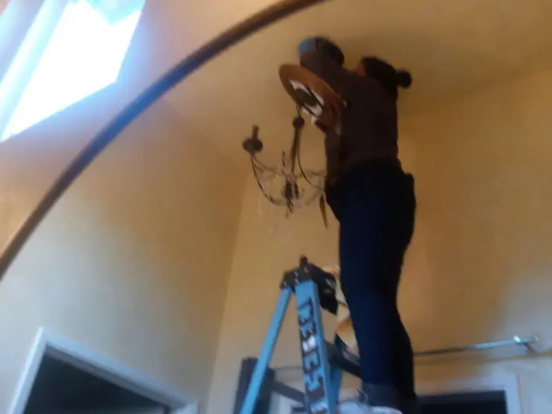 Electrician installing a chandelier in a Jefferson residence